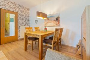 a dining room with a wooden table and chairs at Matjesliebe in Dornumersiel