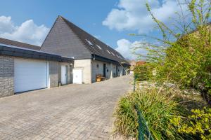 a house with a garage and a brick driveway at Matjesliebe in Dornumersiel