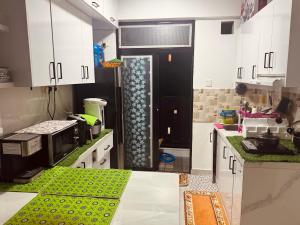 a kitchen with white cabinets and a green counter top at Home Transit Hulhumale' Phase 2 in Male City