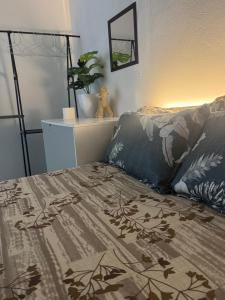 a bedroom with a bed with a blanket and a lamp at Home Transit Hulhumale' Phase 2 in Male City
