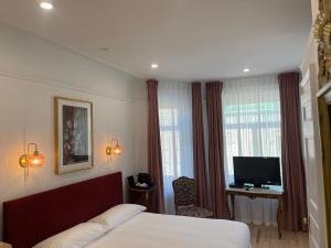 a hotel room with a bed and a television at Le Chateau de Pierre in Quebec City
