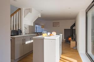 a kitchen with white cabinets and a large window at Crafters Cottage in Sandwich +21 photos