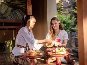 two girls sitting next to a table with food at Velonia Iseh in Sidemen