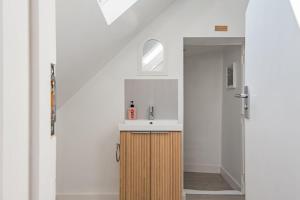 a bathroom with a sink and a mirror at Crafters Cottage in Sandwich