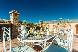 - une table et des chaises sur la terrasse dans l'établissement Riad Nasreen, à Marrakech