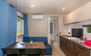 a kitchen with a blue couch and a table in a room at Campeggio La Quiete in Marina di Massa