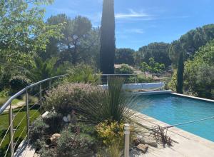 a swimming pool in a garden with plants at la passerelle du couchant in Langlade