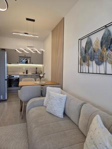 a living room with a couch and a dining room at Szemesbay Serenity Apartman in Balatonszemes