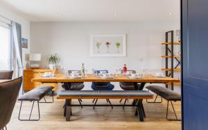a dining room with a wooden table and chairs at Colonels Rest - Luxury Beachside Townhouse with Sea Views in Sandown, Sleeps 10 in Sandown