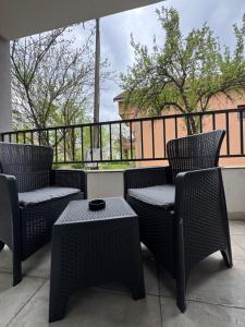 two wicker chairs and a table on a patio at Apartman S in Vrnjačka Banja