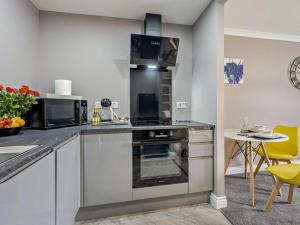 a kitchen with stainless steel appliances and a table with yellow chairs at 1 Bed in Oban oc-96079 in Oban