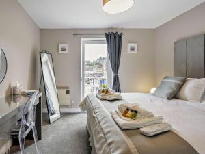 a bedroom with a bed with a table and a window at 1 Bed in Oban oc-96079 in Oban