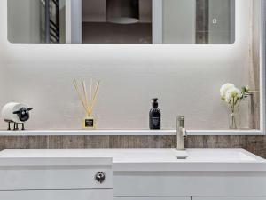 a bathroom sink with a mirror and a bottle on it at 1 Bed in Oban oc-96079 in Oban +10 photos