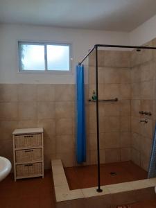 a bathroom with a shower with a blue shower curtain at Miralrio in Santa Rosa de Calamuchita +56 photos