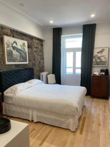a bedroom with a large white bed and a window at Le Chateau de Pierre in Quebec City