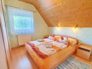 a large bed in a room with a wooden ceiling at Apartment Anikó Nr 7 in Vonyarcvashegy +62 photos
