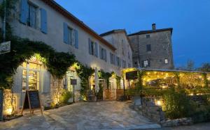 a building with lights in a courtyard at night at Gite de La Cueille - Chambre double in Ribes