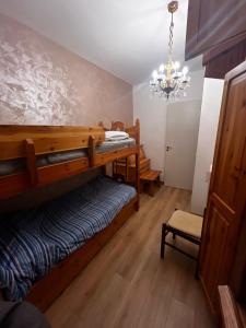 a bedroom with two bunk beds and a chandelier at Appartamento Tulipano in Nevegal