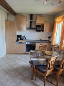 a kitchen with a wooden table and chairs and a tableasteryasteryasteryasteryastery at Ferienwohnung in der Sächsischen Schweiz in Königstein an der Elbe +10 photos