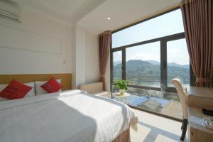 a bedroom with a bed and a large window at Cong Fu Hotel in Bắc Hà