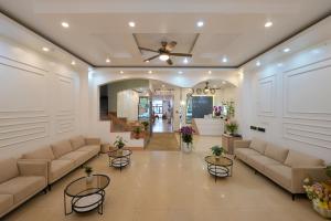 a living room with couches and tables and a ceiling at Cong Fu Hotel in Bắc Hà