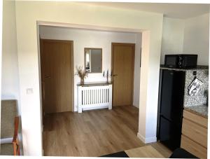 a living room with a black refrigerator and a mirror at Brisa do Mar in Laxe