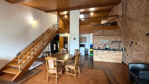 a dining room with a table and chairs and a staircase at Ubytování u Šimků in Broumov