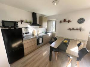 a kitchen with a dining table and a black refrigerator at Brisa do Mar in Laxe