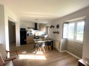 a kitchen and living room with a table and chairs at Brisa do Mar in Laxe +15 photos