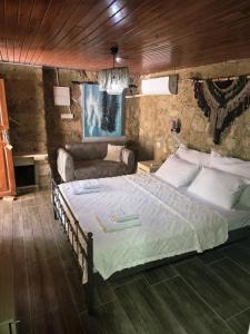 a bedroom with a large bed and a couch at İmerek Taş Ev Otel Alaçatı in Alaçatı