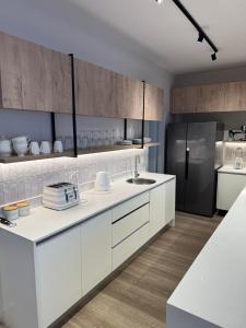 a kitchen with white cabinets and a refrigerator at Duplex in Vainona in Harare