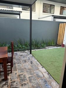 a backyard with a fence and a green lawn at Duplex in Vainona in Harare