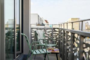 a balcony with two chairs and a table with a drink at appartello - smarttime living Berlin in Berlin