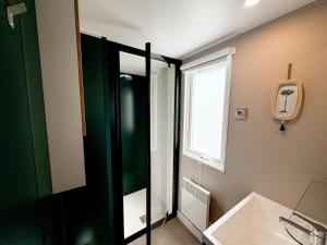 a bathroom with a shower and a sink and a window at Chalet Duin & Zee 44, Renesse in Renesse