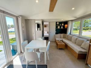 a living room with a couch and a table and chairs at Chalet Duin & Zee 44, Renesse in Renesse