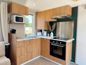 a kitchen with wooden cabinets and a stove top oven at Chalet Duin & Zee 44, Renesse in Renesse +7 photos
