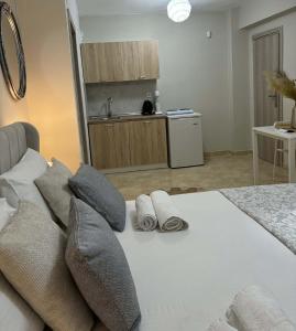 a bedroom with a bed with two pillows and a kitchen at Luxury Villa Vista in Tsouknída