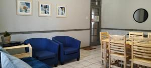 a living room with blue chairs and a couch at AMBROZIA Apartment-self catering-2bed2bath in Bloemfontein