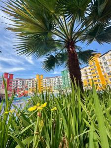 a palm tree with buildings in the background at Platinum - Sun-kissed Holidays Goa in Dabolim