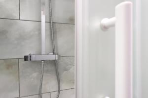 a shower door with a shower head in a bathroom at Studio - Kitchen - Parking - Ideal for Contractors in Swansea