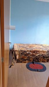 a bed in a room with a rug on the floor at Charles in Presidente Prudente