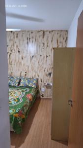 a bedroom with a bed and a wooden floor at Charles in Presidente Prudente