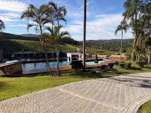 a boat on a river with a picnic table and palm trees at Hotel Boutique Vila don Patto in São Roque