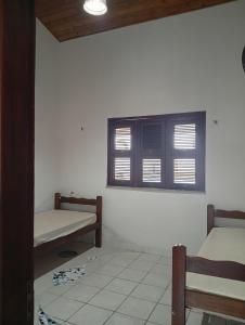 a room with two beds and a window at Casa Carlotta in Paracuru