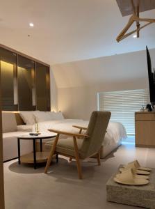 a bedroom with a bed and a table and a chair at Hotel Inspiroom Jongro in Seoul