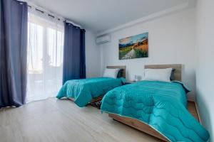 a bedroom with two beds and a window at Superlative 3BR Penthouse, Private Pool and Views in Hal Ghaxiak