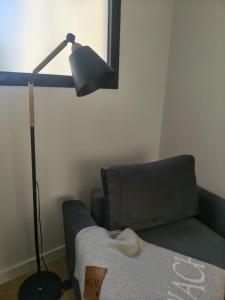 a lamp in a living room next to a couch at A Estrenar Estudio las Cañitas in Buenos Aires