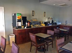 a restaurant with a counter with tables and chairs at Americas Best Value Inn Bishop/Kingsville in Bishop