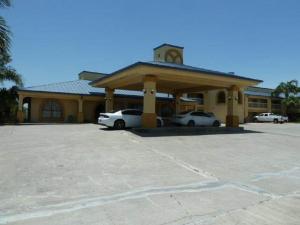 un edificio con dos coches estacionados en un estacionamiento en Americas Best Value Inn Bishop/Kingsville, en Bishop