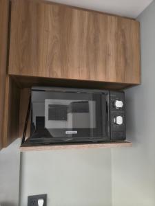 a black microwave sitting on a shelf in a kitchen at A Estrenar Estudio las Cañitas in Buenos Aires